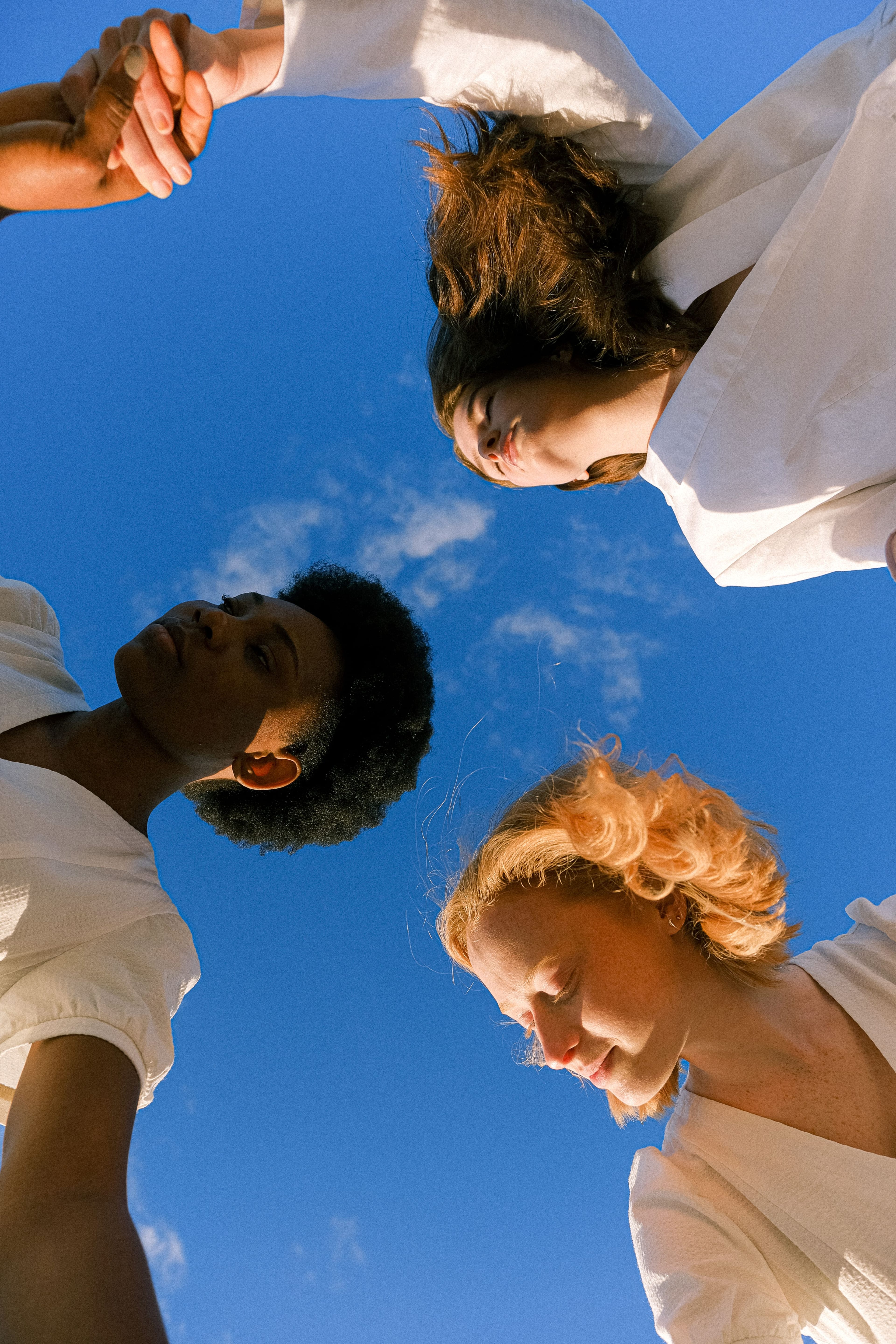 Trois personnes se tiennent par la main et regardent le ciel